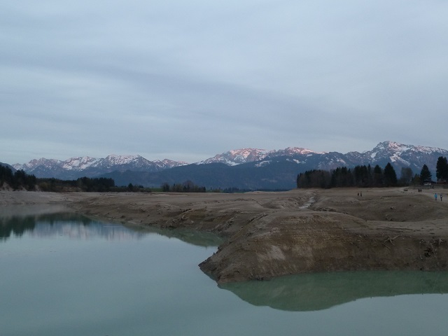 Alpenglühen hinter dem Forggensee ohne Wasser