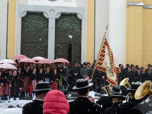 Traditionelles Fahnenschwingen vor der Kirche in Oberstaufen am Fasnatziestag