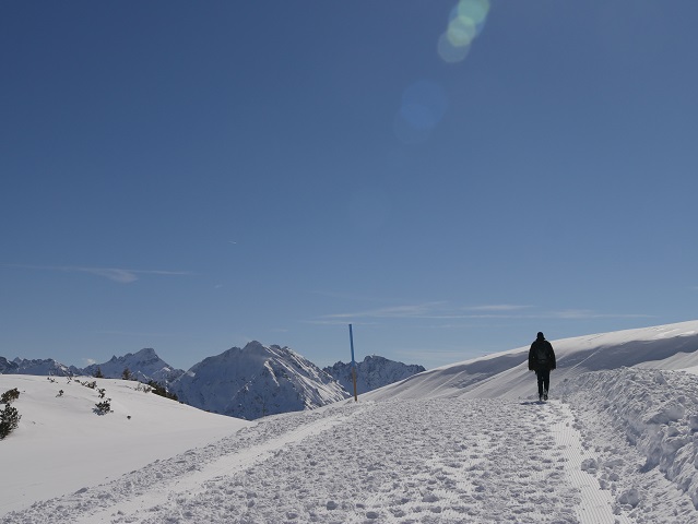 Wanderer im Schnee vor Berggipfeln
